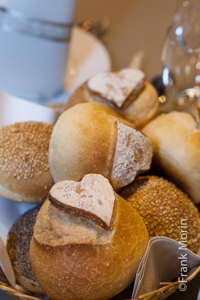 Détail de décoration des tables dans la salle du banquet : des formes de cœur sur les pains