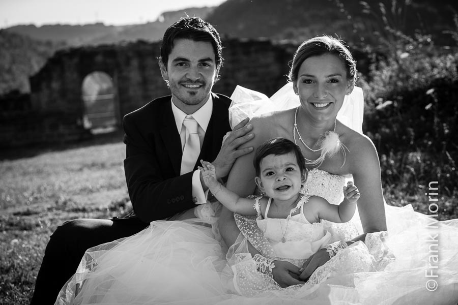 portrait des mariés assis dans l'herbe avec leur bébé, en Noir et Blanc