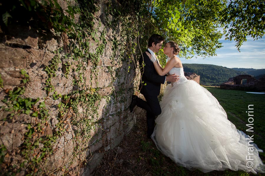 Les mariés face à face le long d'un vieux mur en pierres