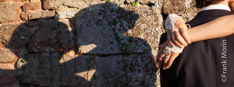 l'ombre des mariés projettée sur un vieux mur en pierres