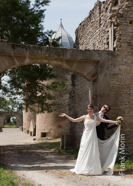 Portrait des mariés avec la robe de mariage à l'entrée du château