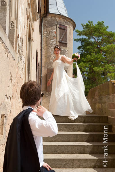 Les mariés dans un escalier à l'extérieur du château