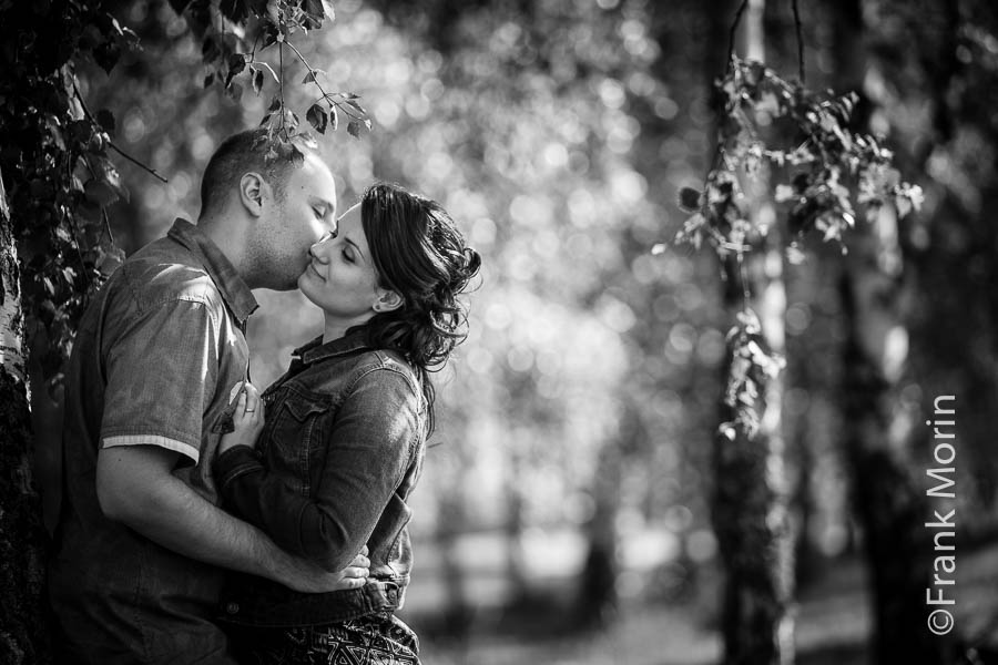 Les fiancés s'embrassent appuyés à un arbre, en Noir et Blanc