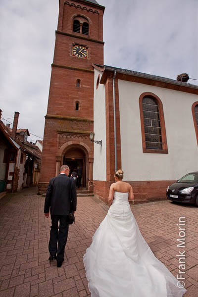 De dos, la Mariée marche vers la porte de l'église