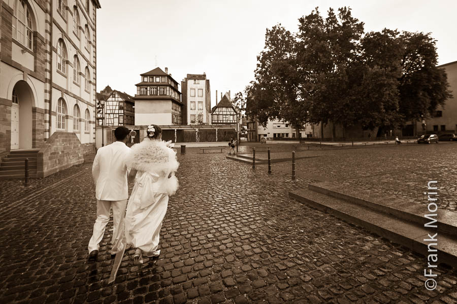Les mariés marchent dans une ruelle de Strasbourg, en noir & blanc sépia