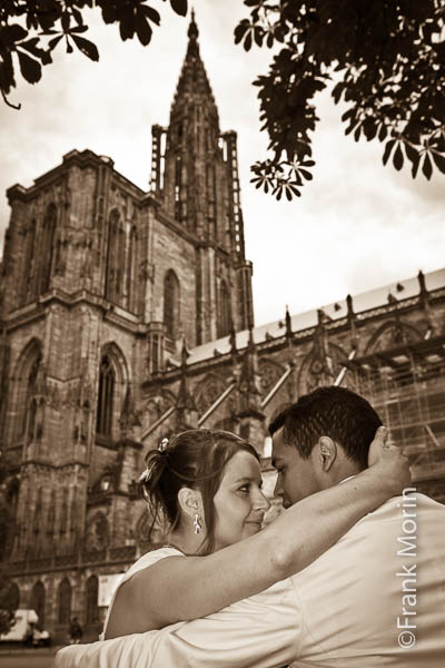 Les mariés les yeux dans les yeux, sur banv au pied de la cathédrale