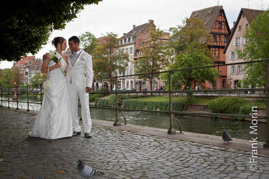 Sur les quais de l'Ill, les mariés se regardent dans les yeux, deux pigeons posés au sol