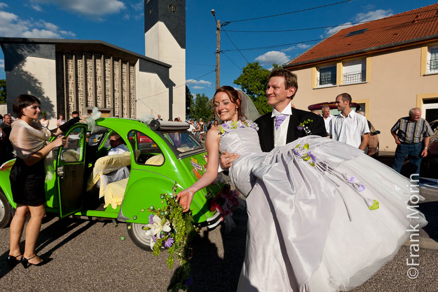 Le Marié porte son épouse vers la voiture 2CV