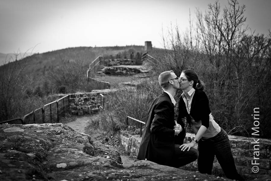 Les fiancés s'embrassent sur une terrasse.