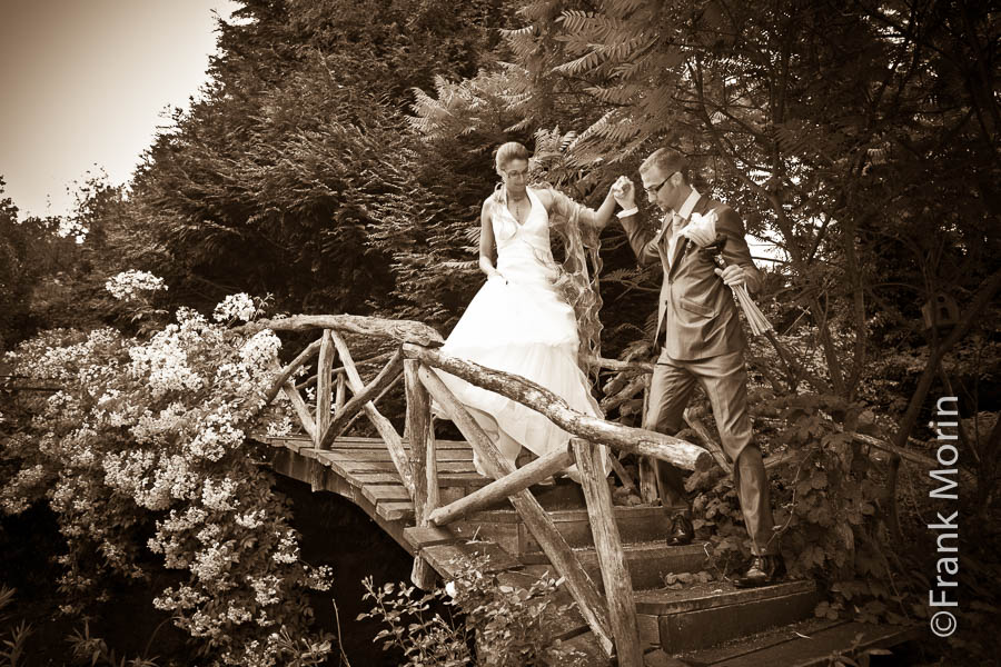 Le fiancé aide sa compagne à passer une passerelle de bois.