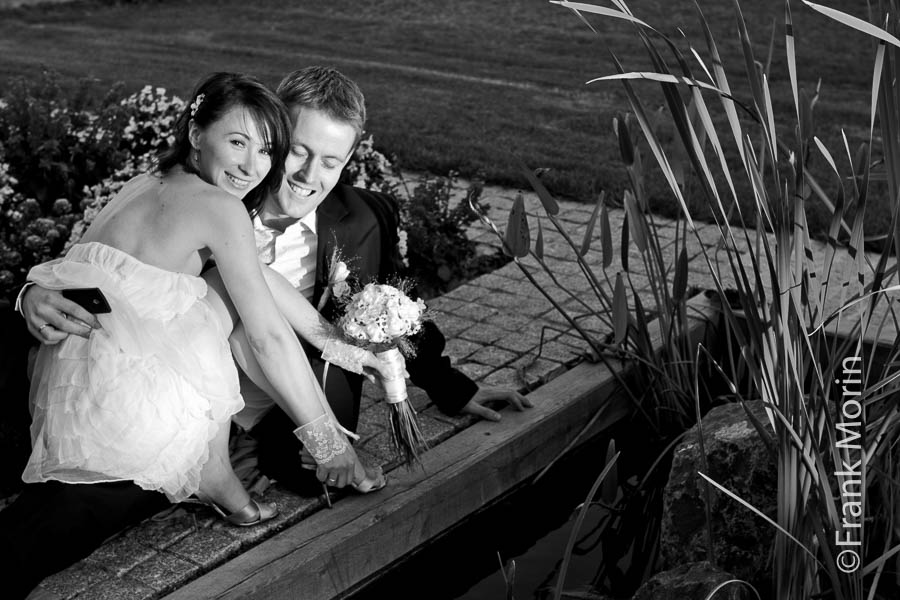 Les mariés au bord d'un bassin avec des plantes aquatiques